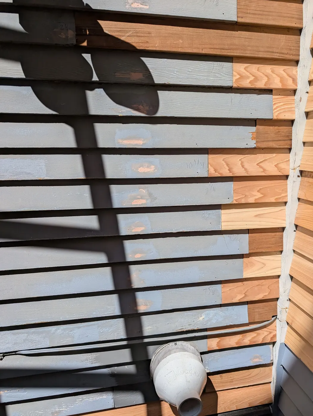 Close-up of new cedar siding installed next to older weathered boards on a Vancouver duplex exterior