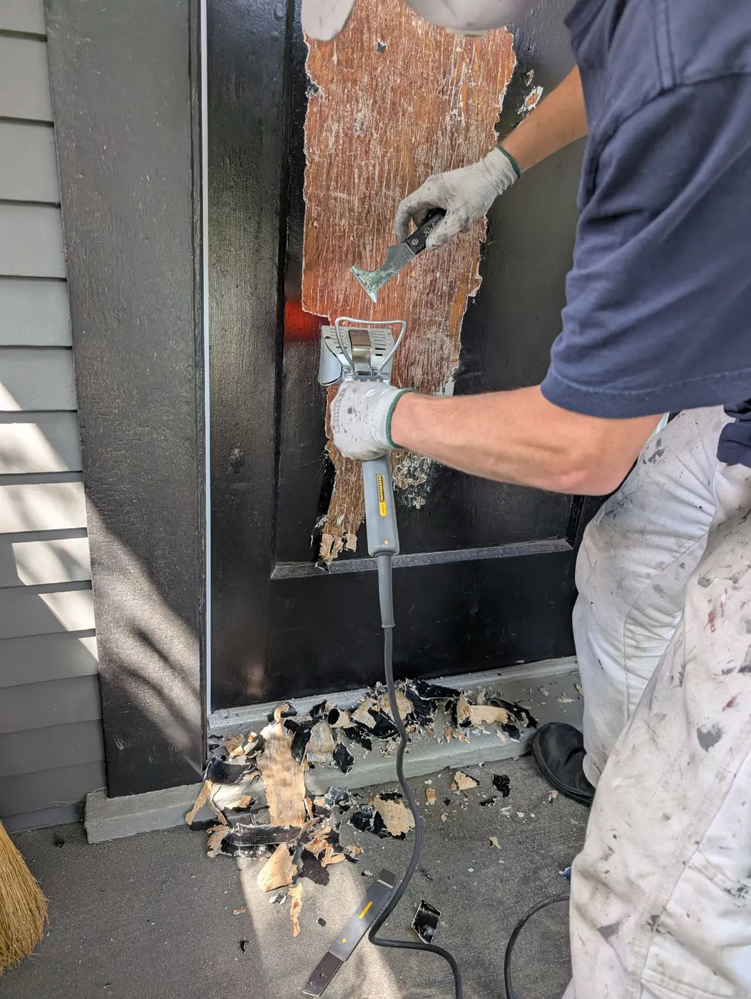 Carpenter removing rotted wood trim during exterior repairs on a Vancouver, BC duplex