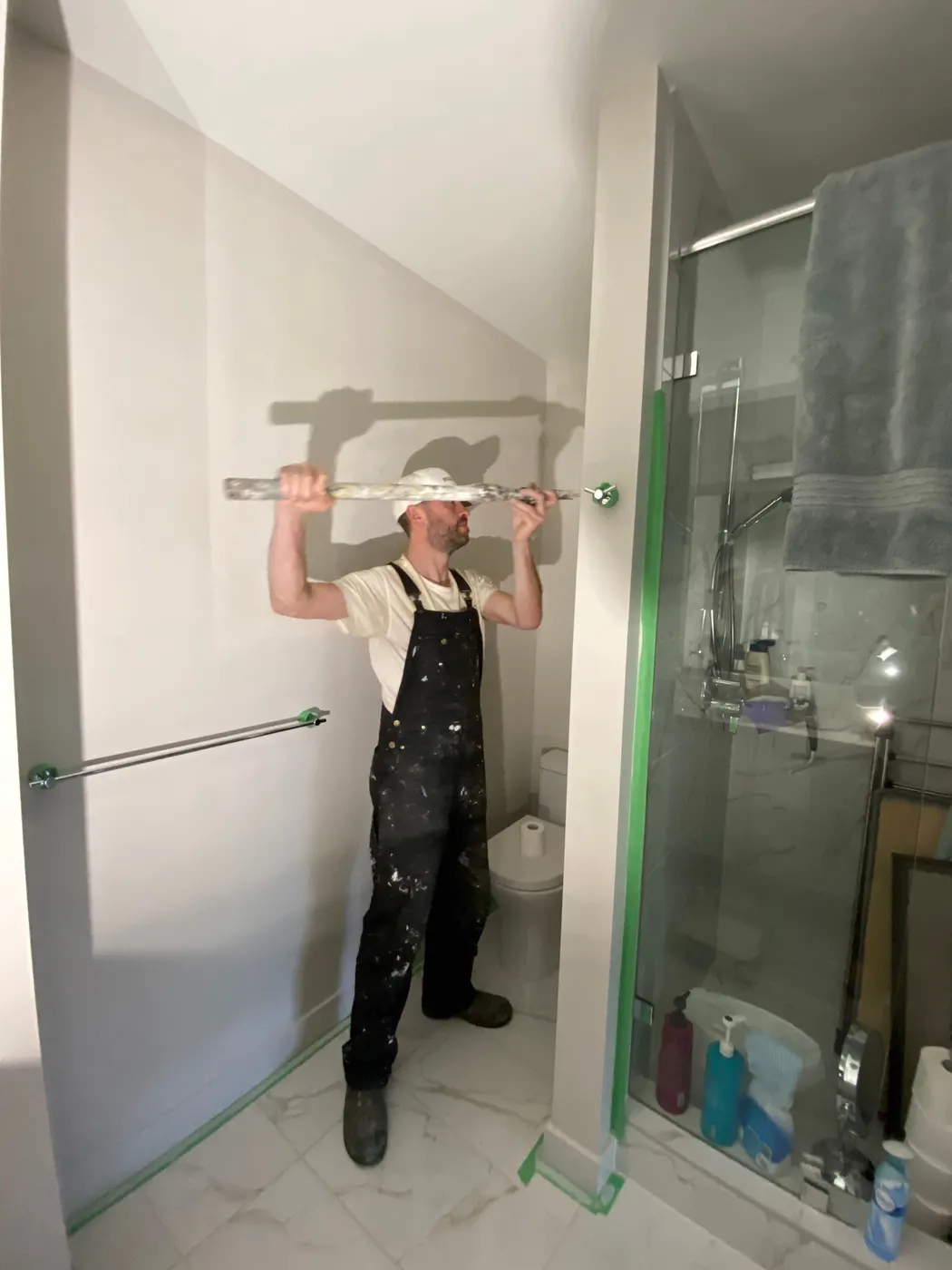 A Renaissance Painting carpenter installs a towel bar in a renovated Vancouver, BC bathroom.