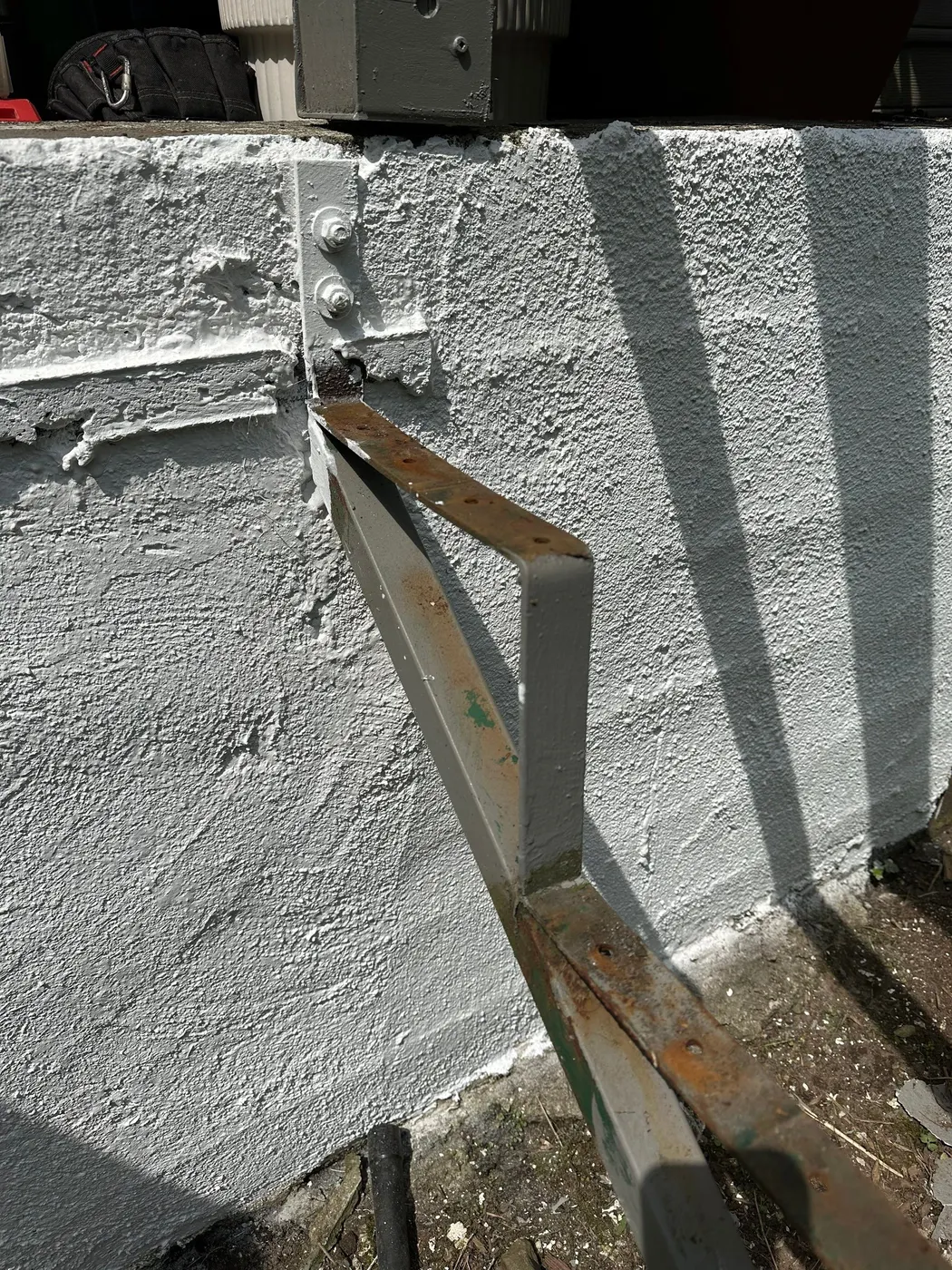 Painter working beneath a freshly painted grey rear deck and stairs in Vancouver, BC