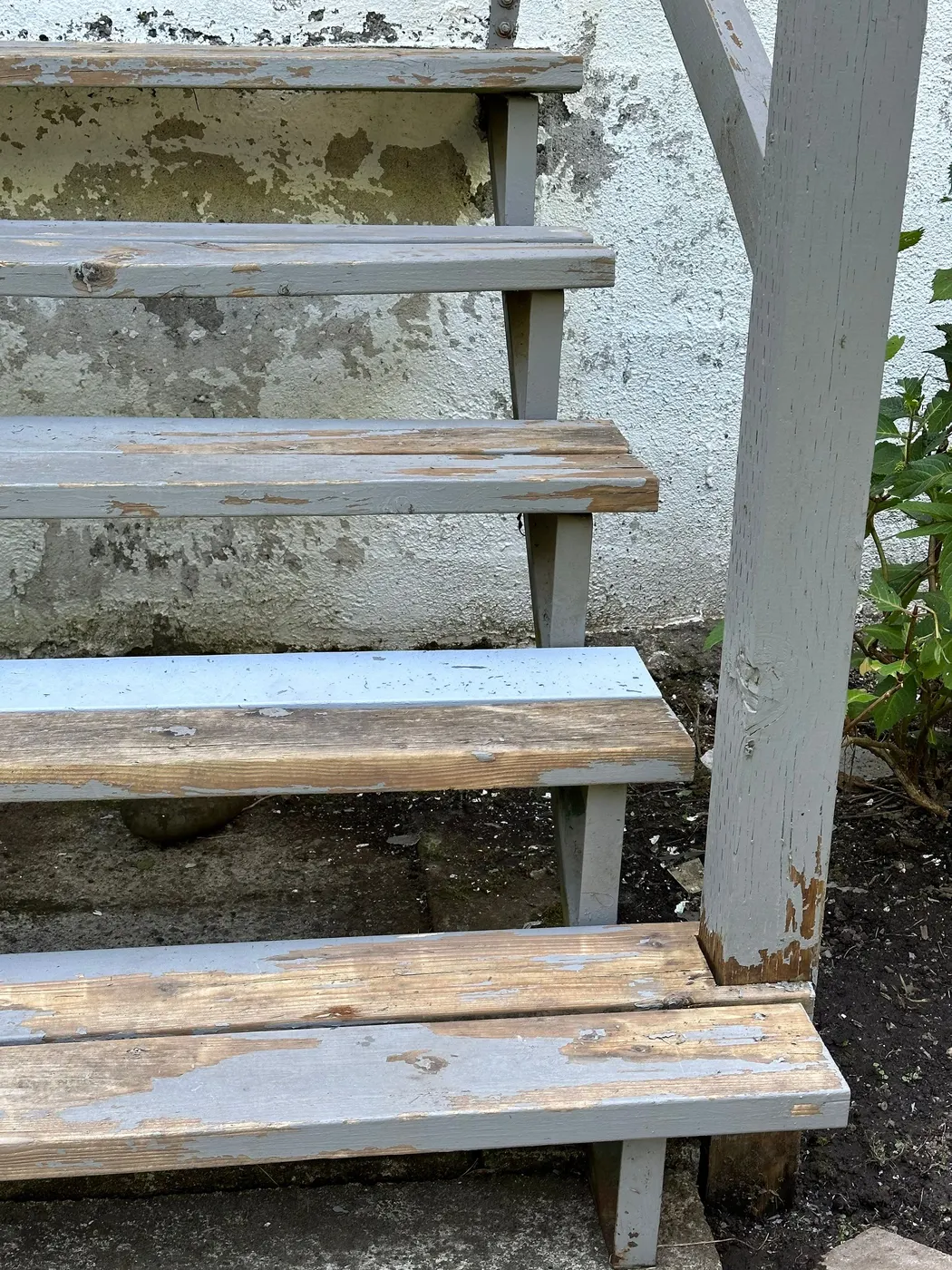 Close-up of peeling paint on wooden exterior stairs before restoration in Vancouver