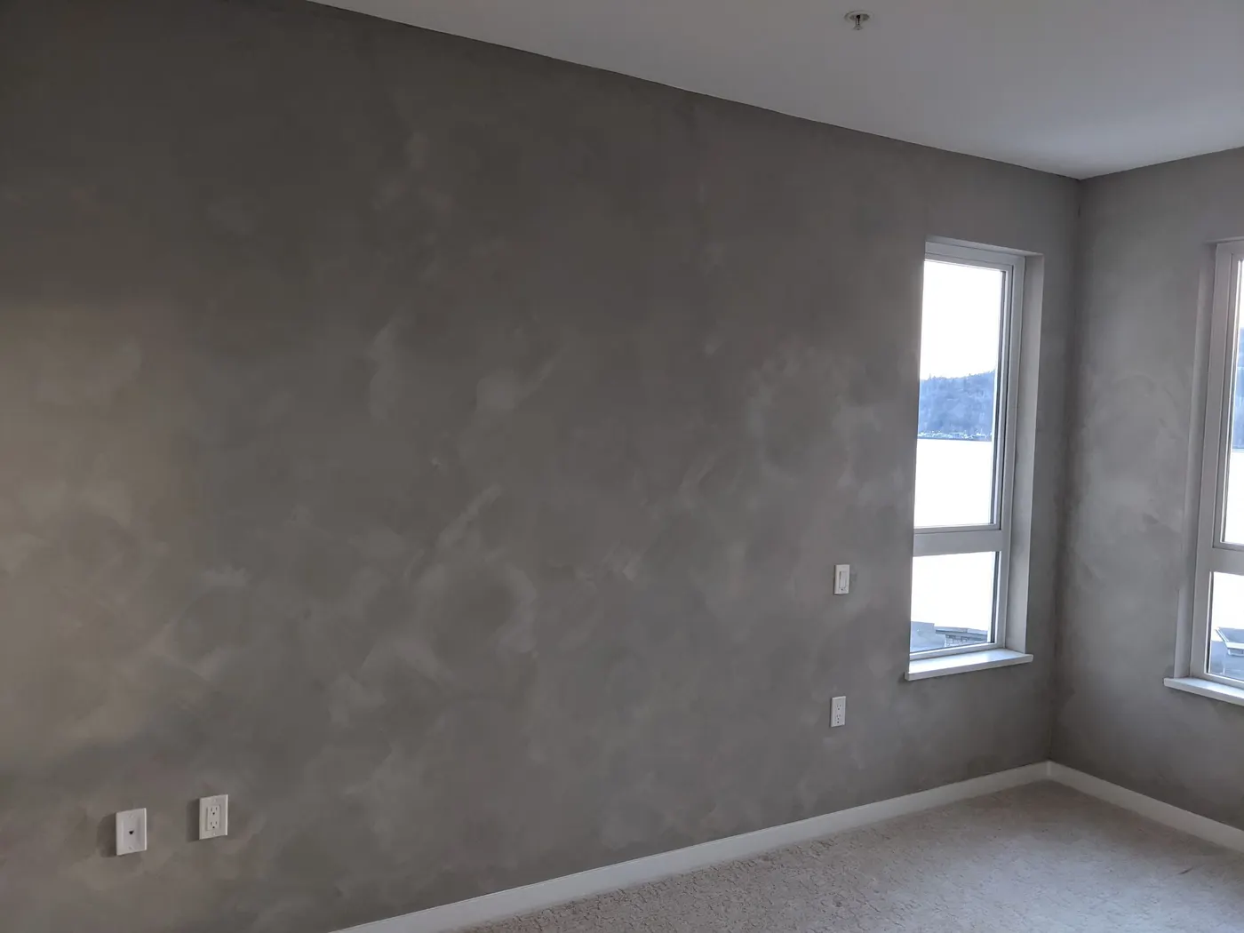 Textured grey accent wall in a Vancouver, BC condo bedroom overlooking the harbour.