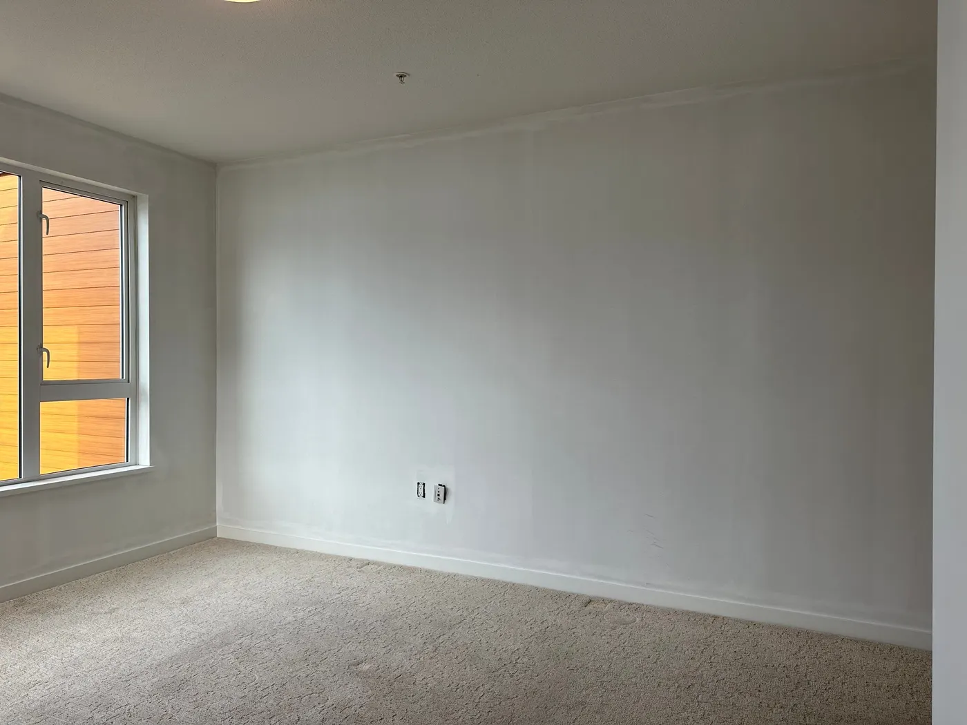 Freshly painted white bedroom walls with natural light in a Vancouver, BC condo interior repaint.