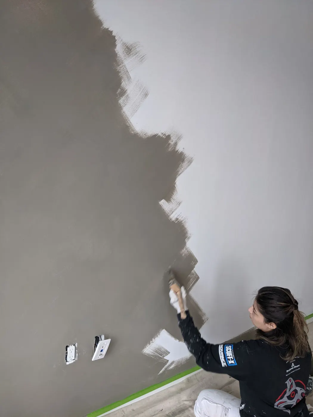 Renaissance Painting crew member applying grey Venetian plaster to a bedroom accent wall in this Vancouver, BC condo.