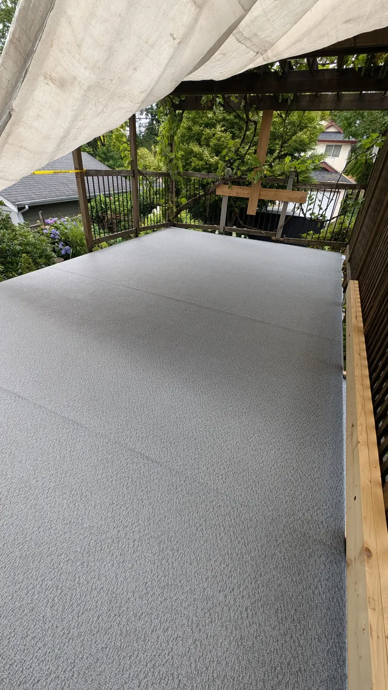 Finished grey vinyl deck membrane under a wooden pergola on a Vancouver, BC home