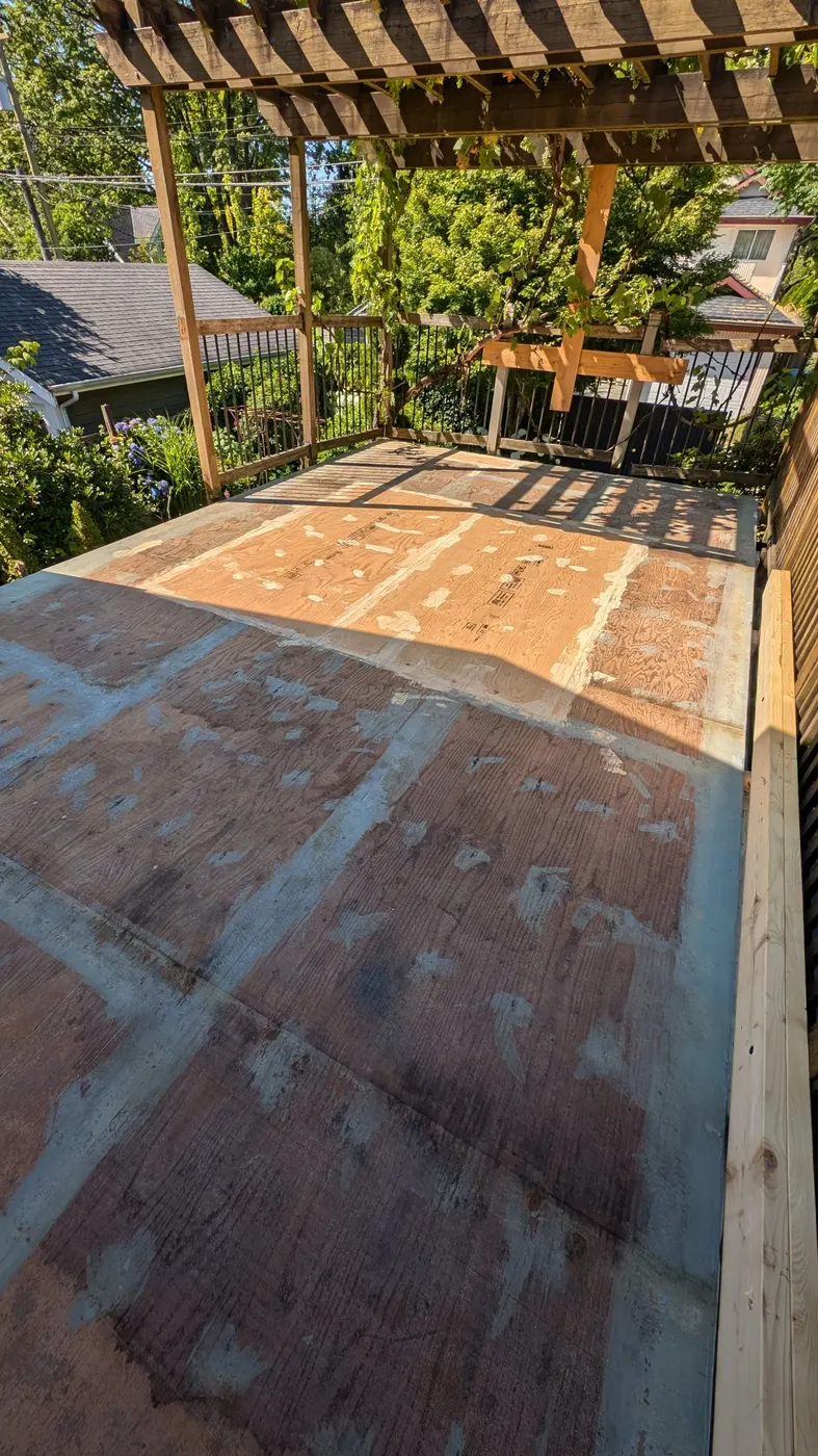 New vinyl deck membrane being installed next to old plywood on a Vancouver, BC deck
