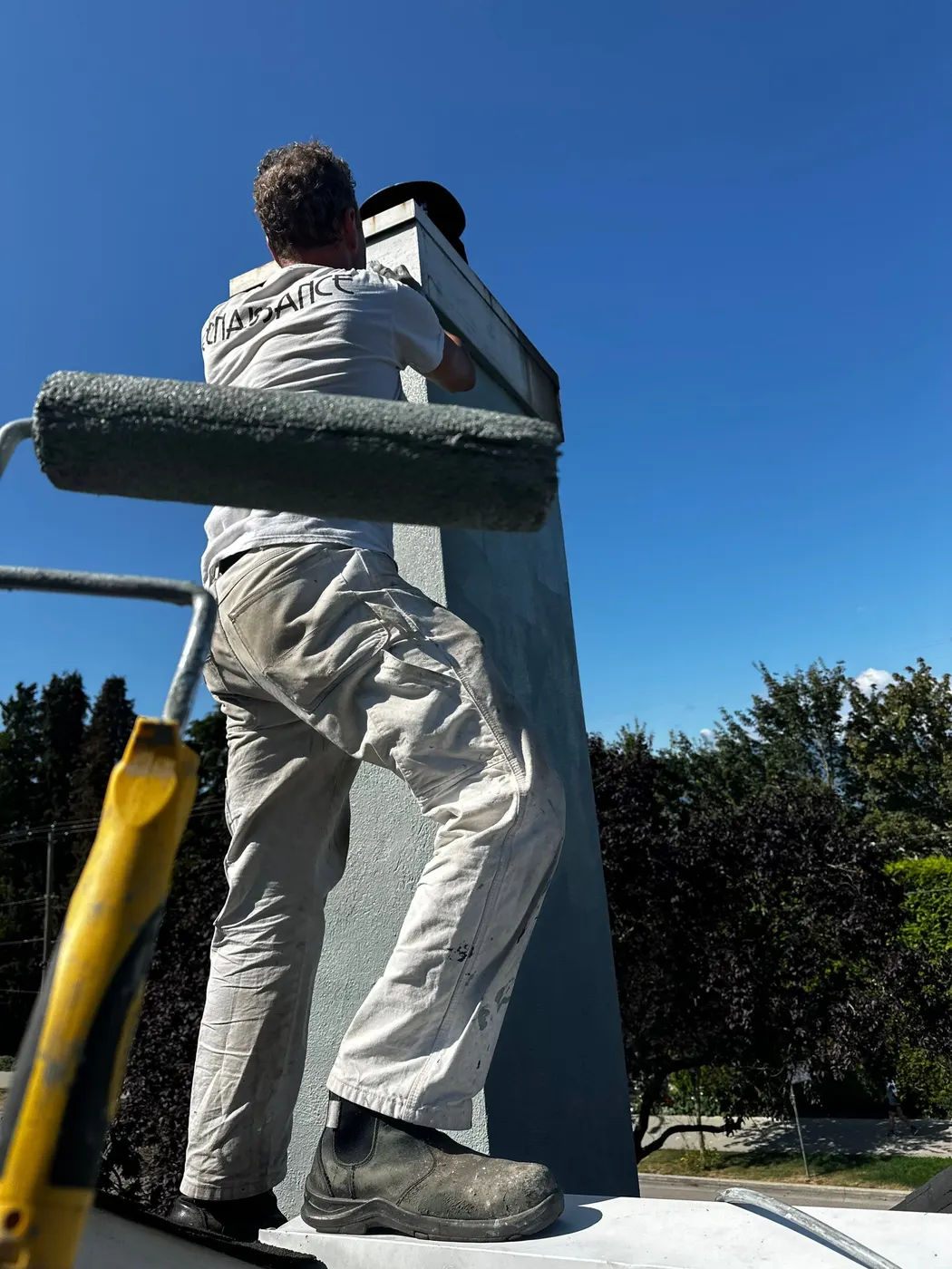 Renaissance Painting crew member sanding a wood porch railing in preparation for repainting in Vancouver, BC