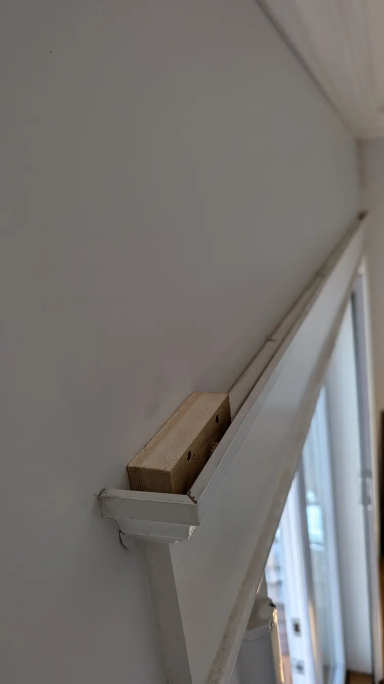 Carpenter installing a wood repair block into window trim during a Vancouver, BC renovation