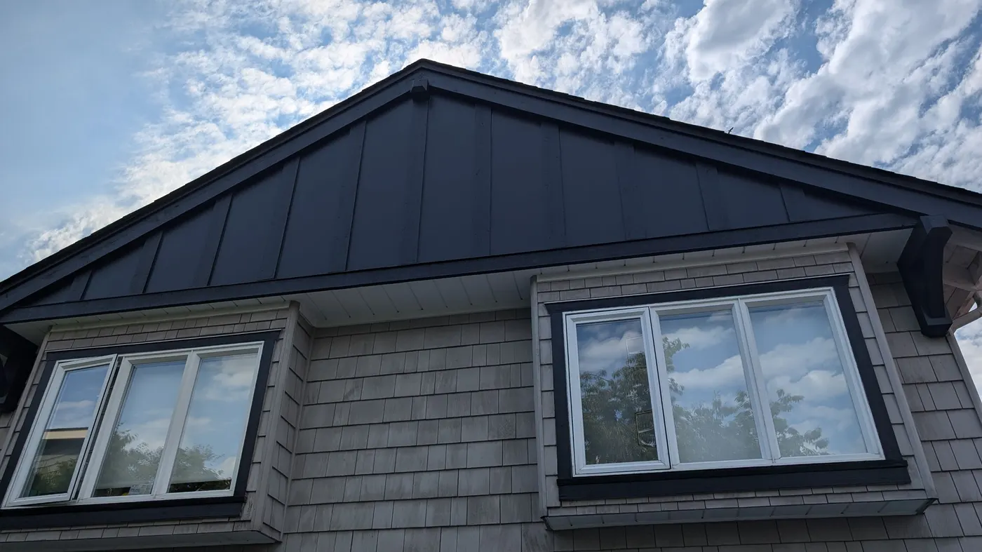 Renovated craftsman home exterior with black trim and dormer windows under blue sky in Vancouver, BC