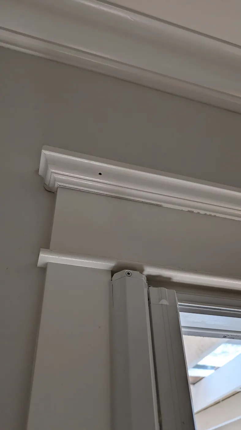 Freshly painted crown molding and door trim corner in a Vancouver, BC home carpentry and trim project