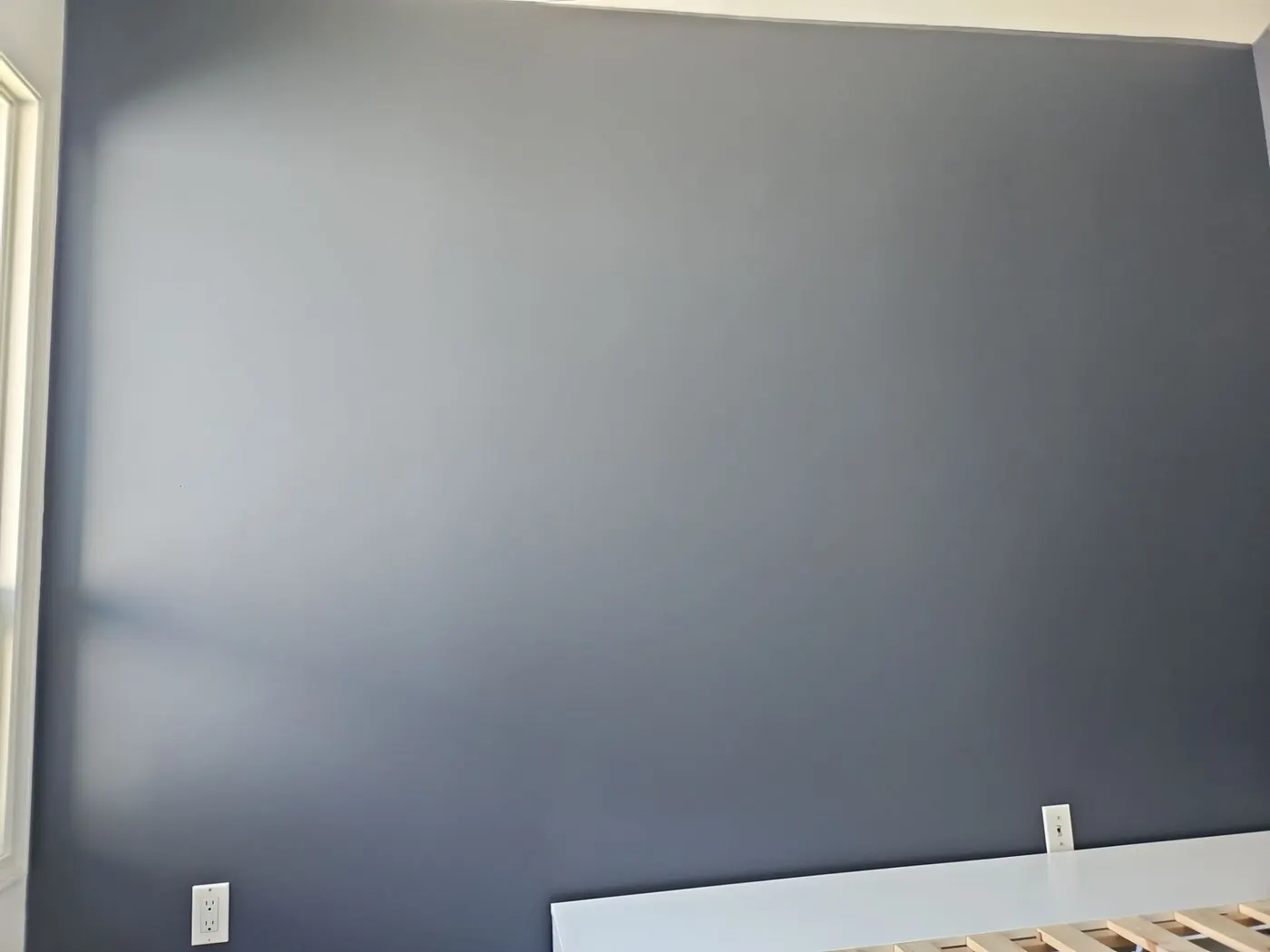 Navy accent wall beside a window with tree views, painted by Vancouver interior painters Renaissance Painting