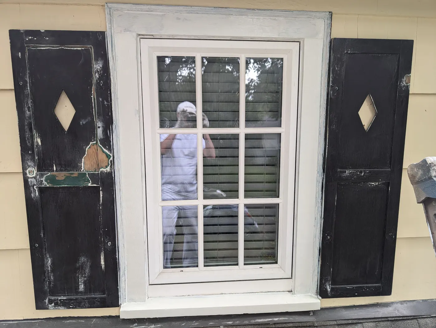 Detail view of a freshly painted black shutter and window trim on a Vancouver home's upper dormer.