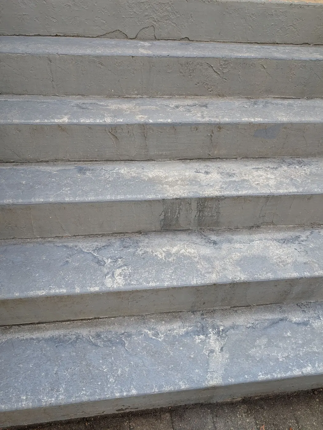 Worn painted concrete front steps showing surface wear and staining before repainting on a Vancouver, BC home.