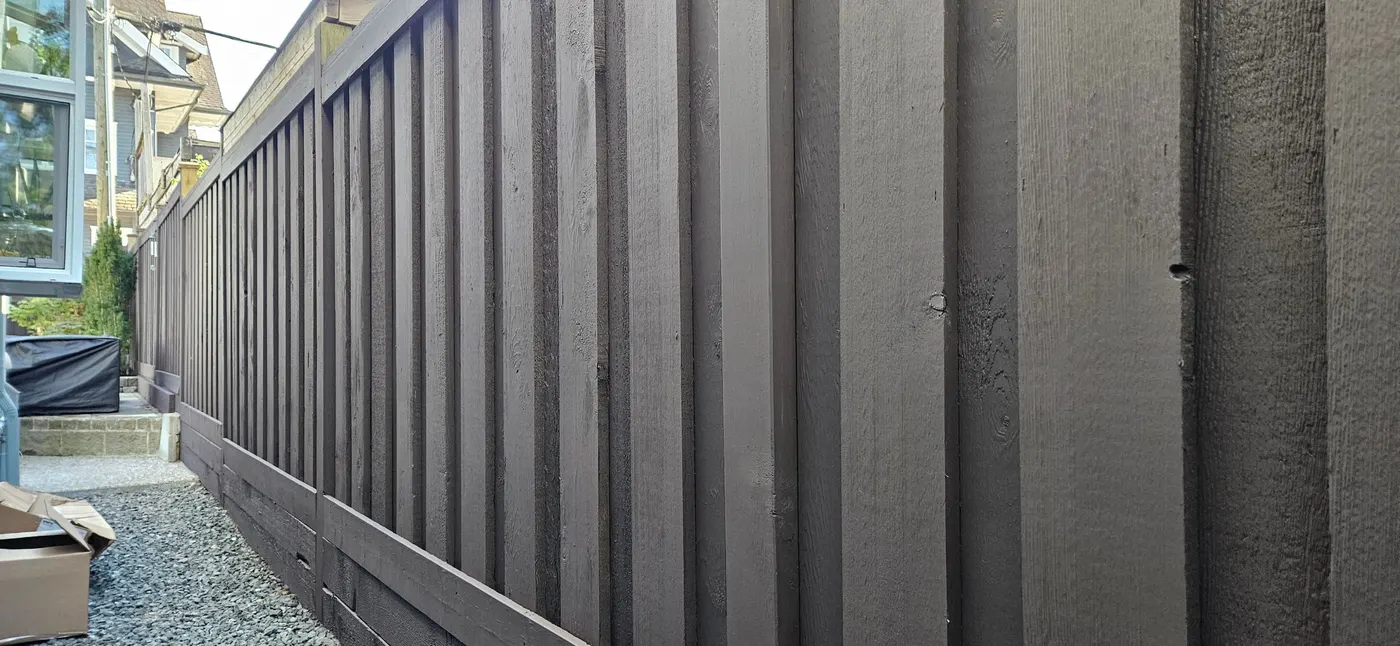 Freshly painted dark gray wood fence along a side yard walkway at a Vancouver, BC home.