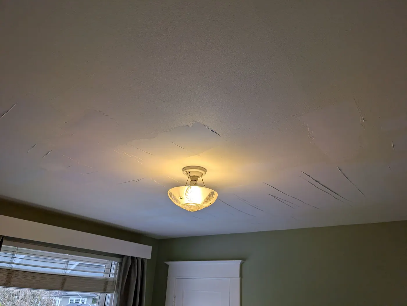 Cracked plaster ceiling before repair in a Vancouver, BC character home bedroom