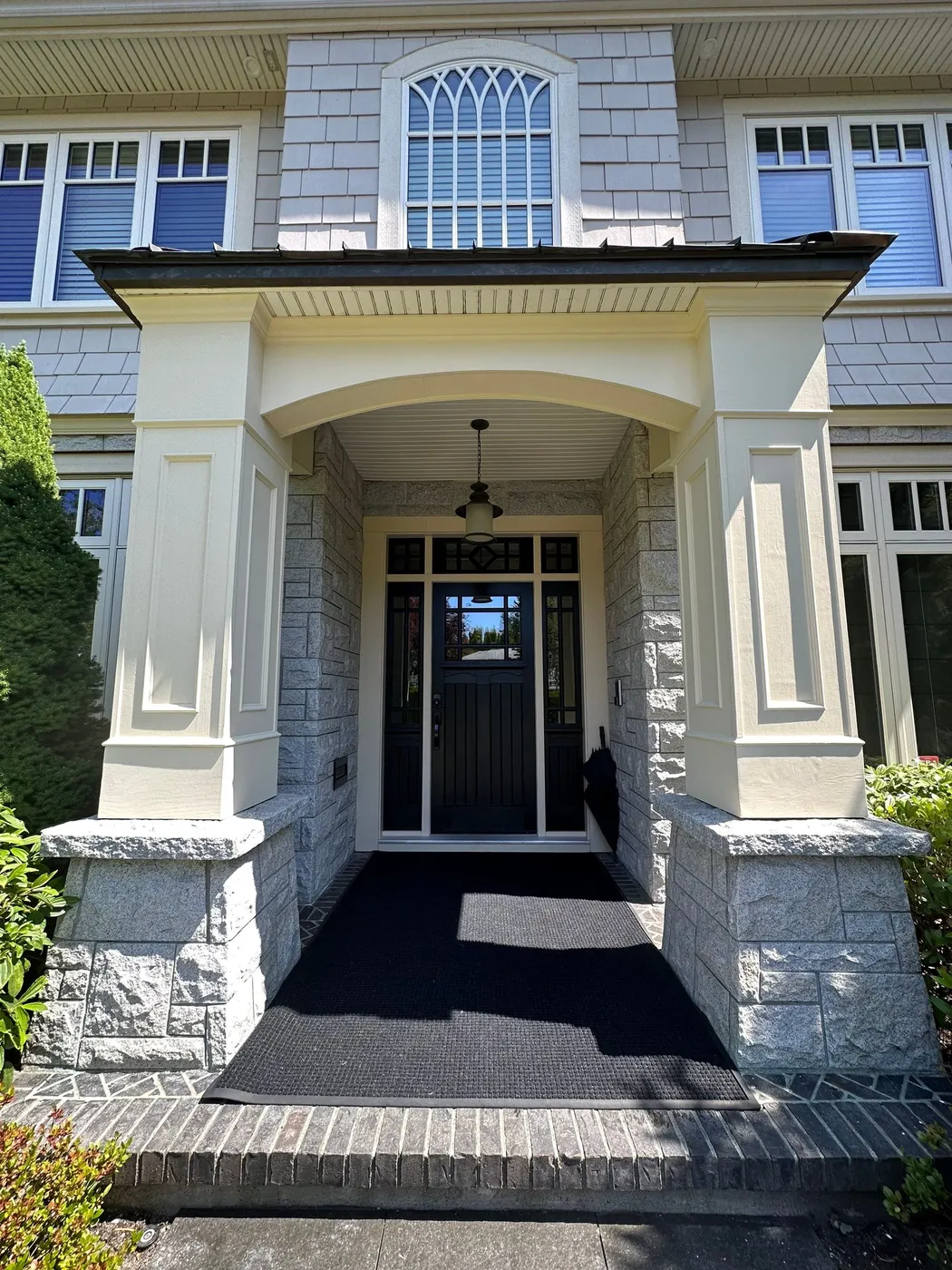 Freshly painted cream columns and portico framing a black front door at a home in Beechwood, Vancouver, BC.