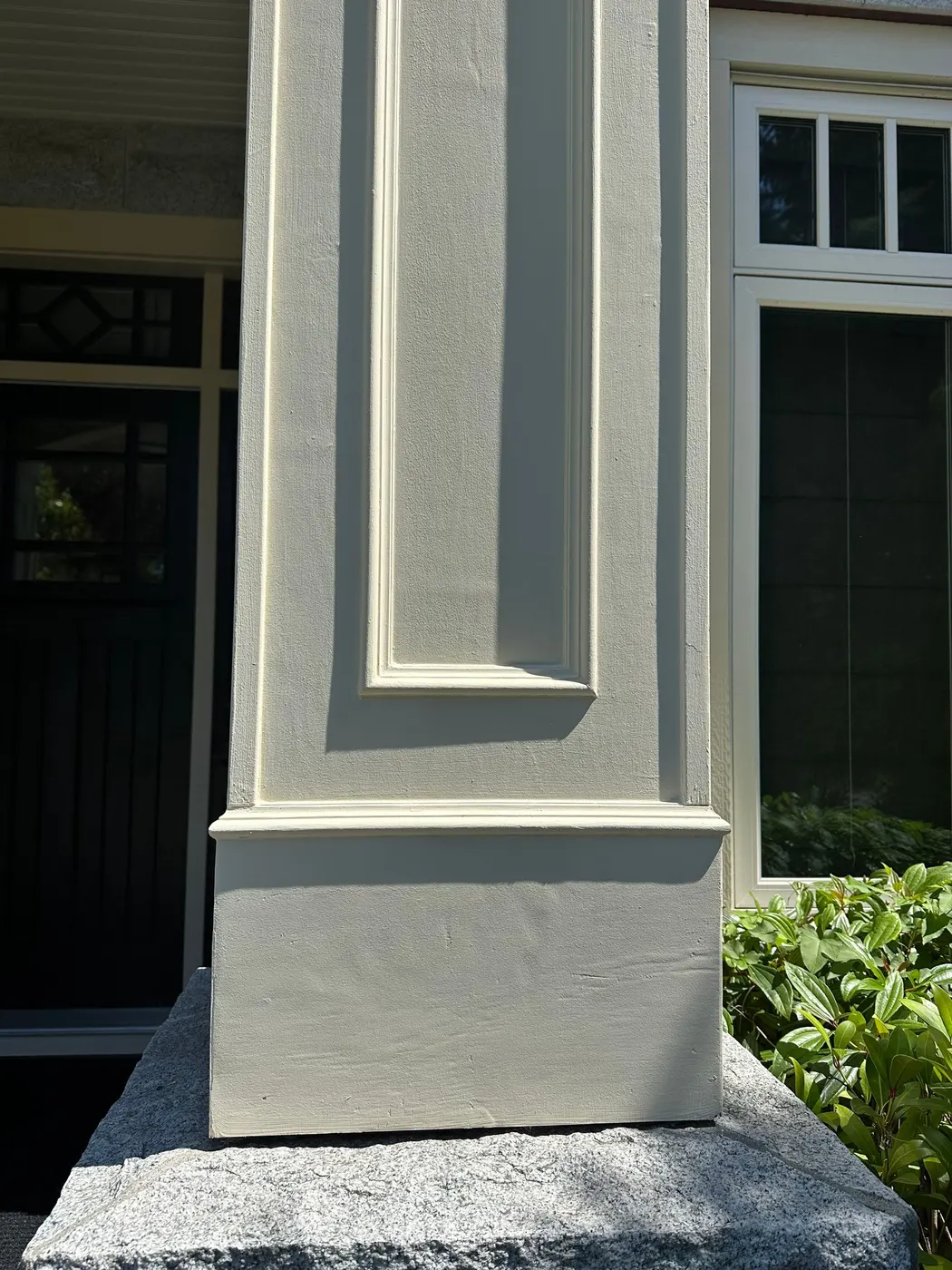 Freshly painted cream porch column base on a stone pedestal at a home entrance in Beechwood, Vancouver, BC.