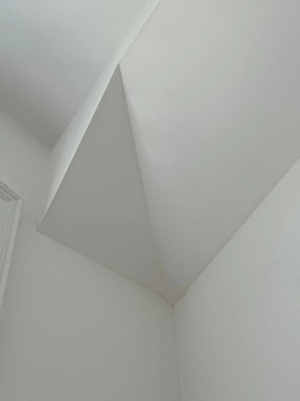 Painter applying white paint to wainscoting panel trim inside a home in Beechwood, Vancouver, BC.