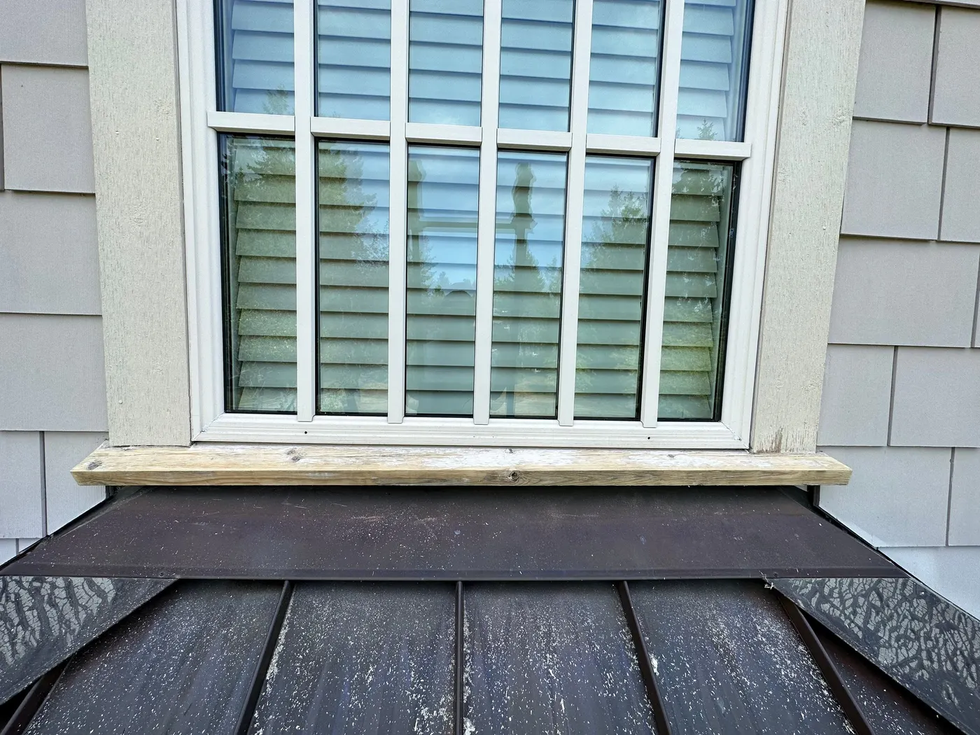 Close-up of peeling paint and rusted nail heads on exterior window trim before repair in Beechwood, Vancouver, BC.