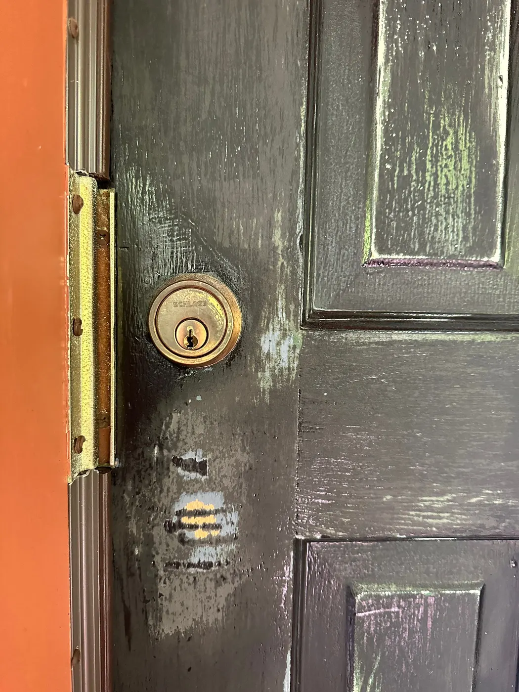 Worn brass deadbolt hardware on a Vancouver home's front door before repainting