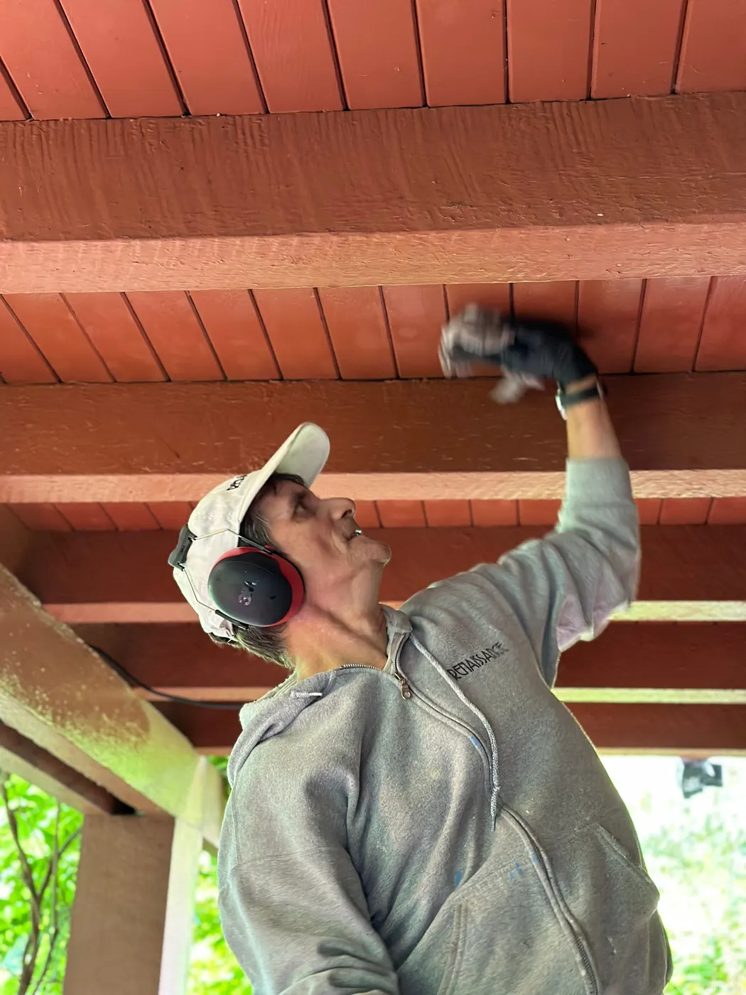 Painter with Renaissance Painting applies fresh exterior paint to soffit trim on a Vancouver character home