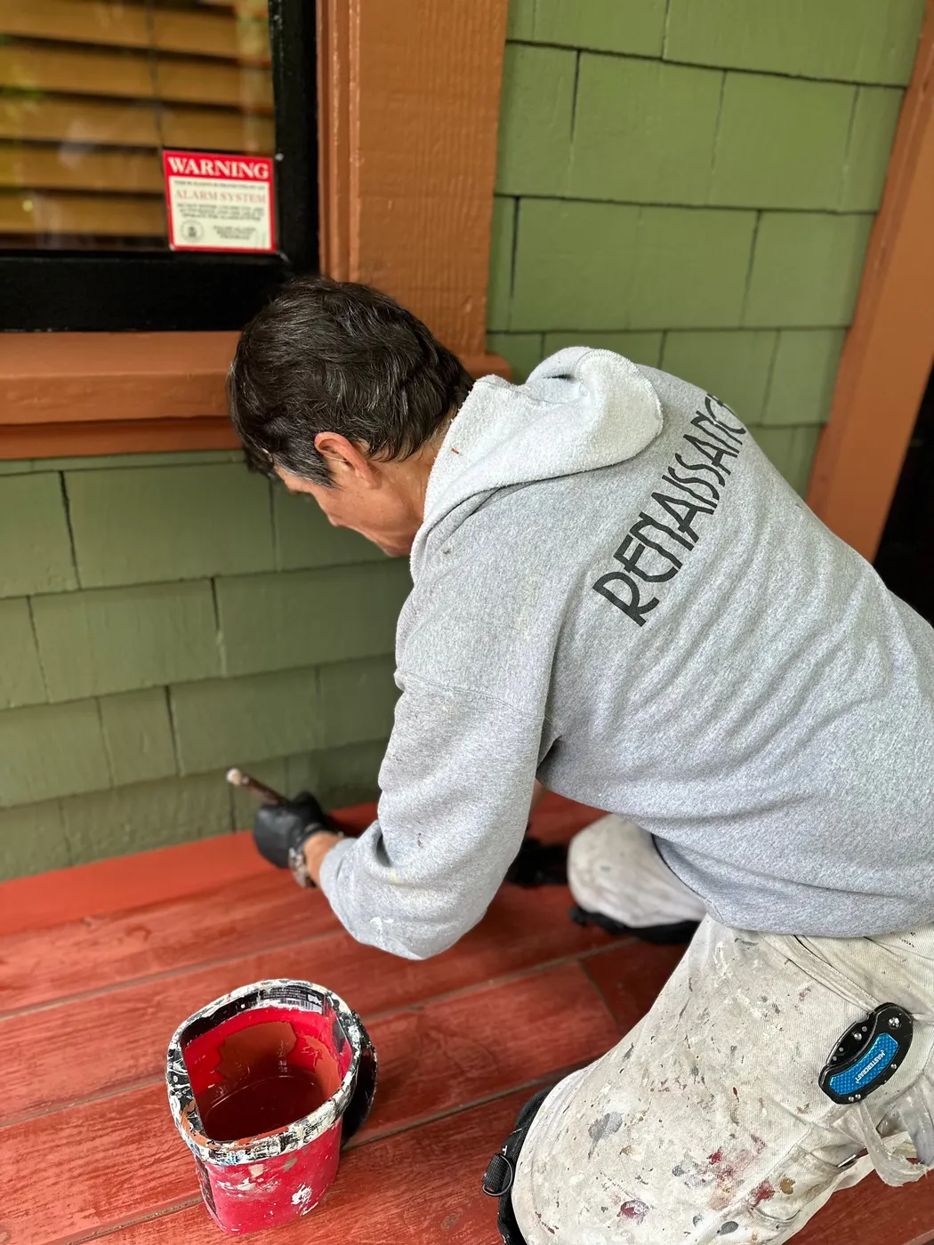 Renaissance Painting crew member hand-painting a window frame on a Vancouver character home