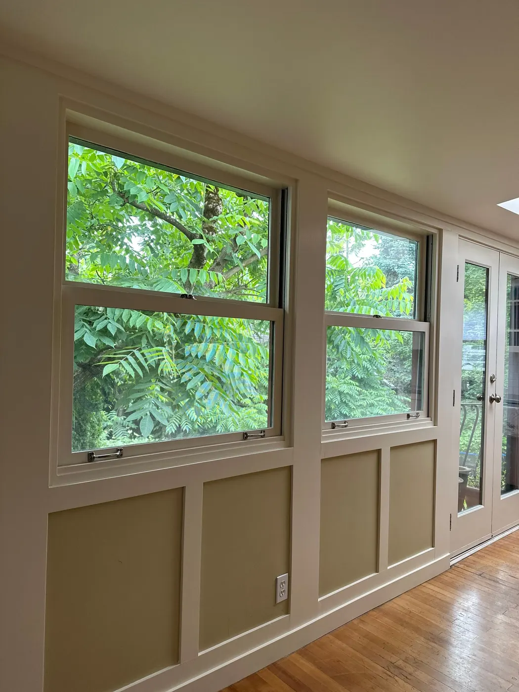 Finished dining nook with freshly painted wainscoting and window trim in a Vancouver home.
