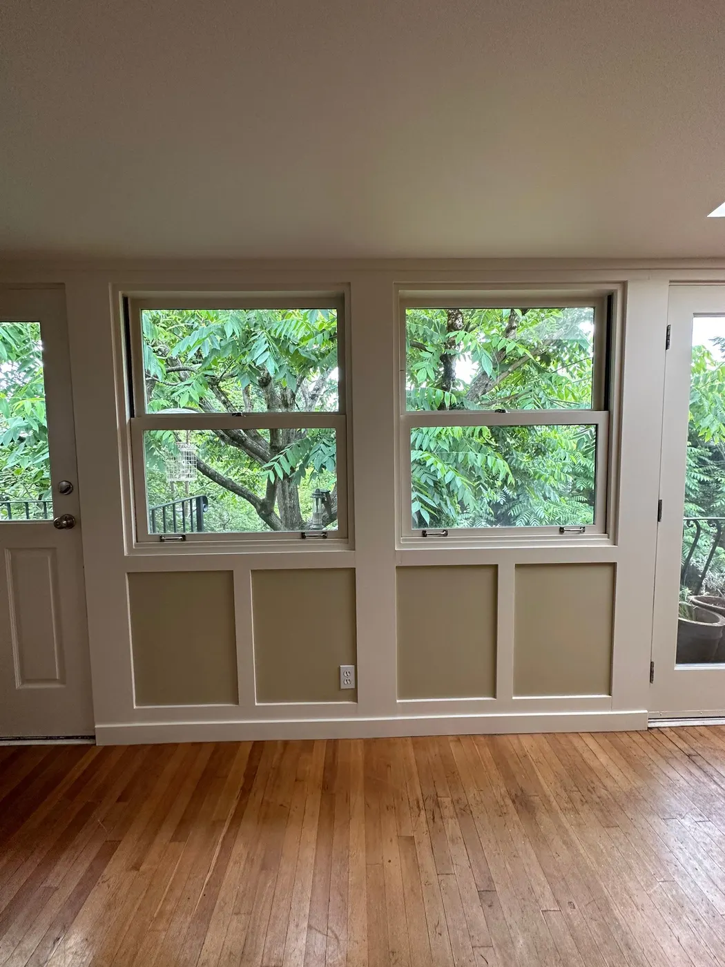 Finished living room with freshly painted walls, windows, and wainscoting in a Vancouver home.