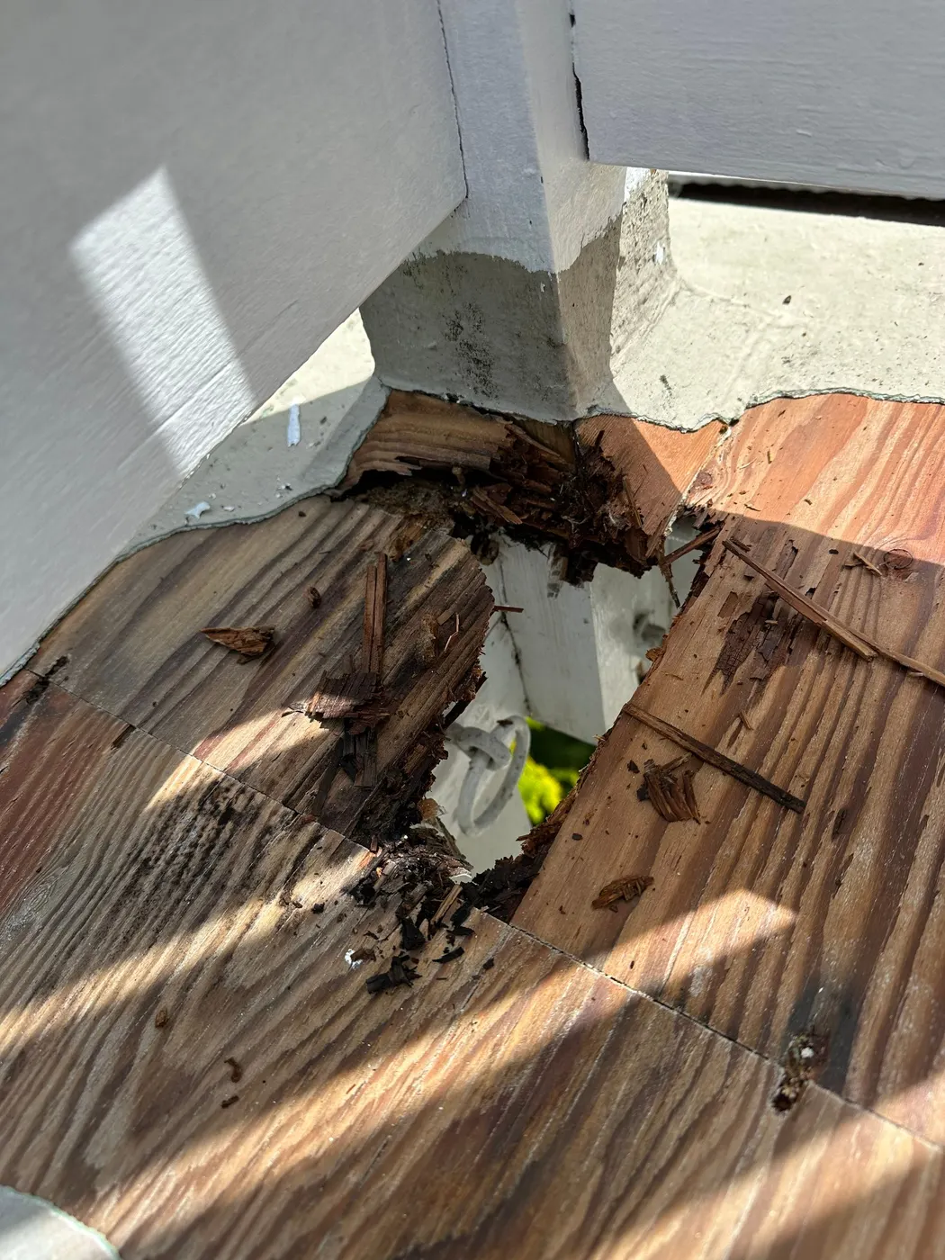 Large hole in rotted deck flooring exposing framing below, found during a Vancouver deck repair project