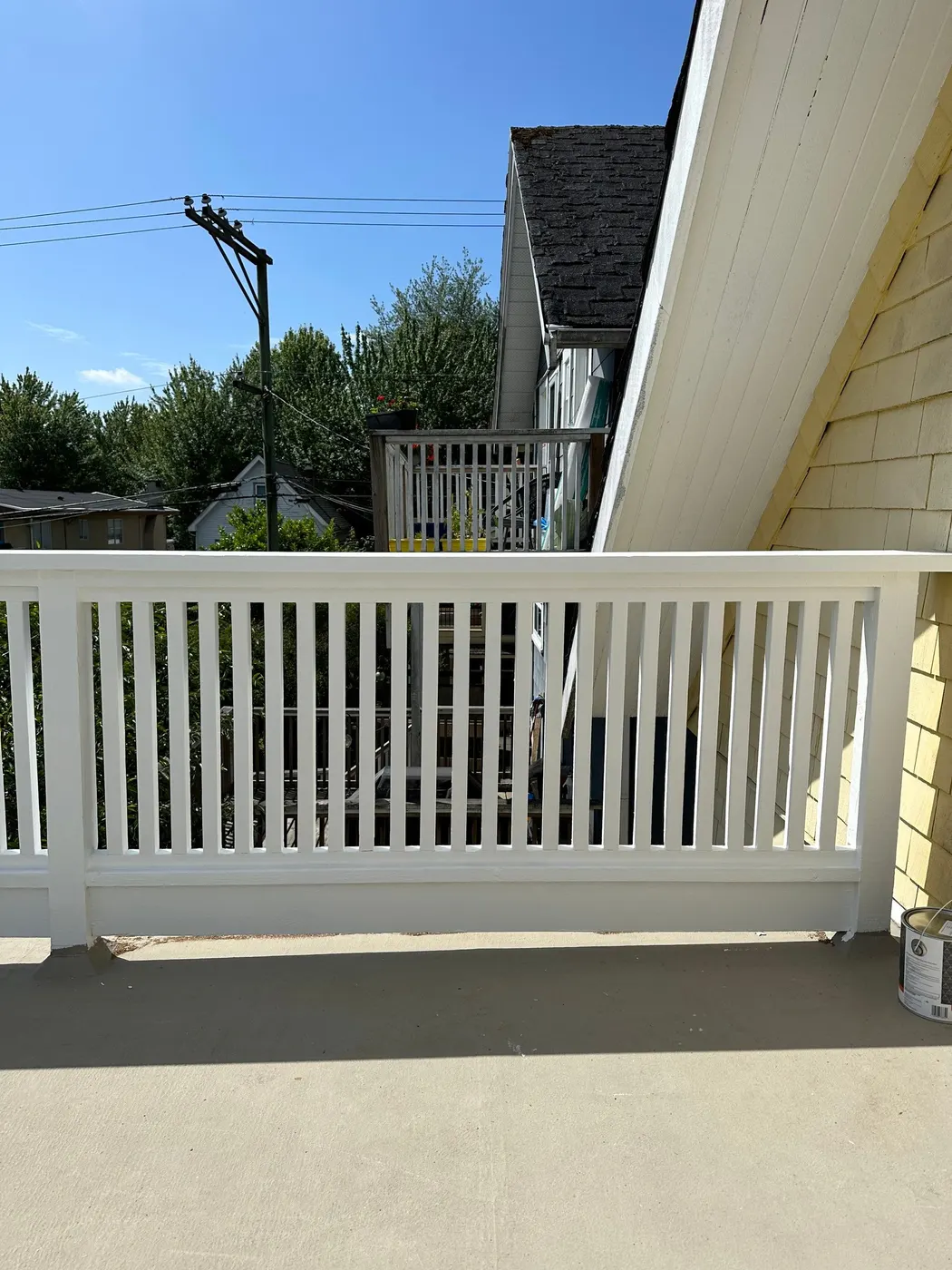 Renovated deck and yellow shingle house exterior in Vancouver, BC after painting and repair