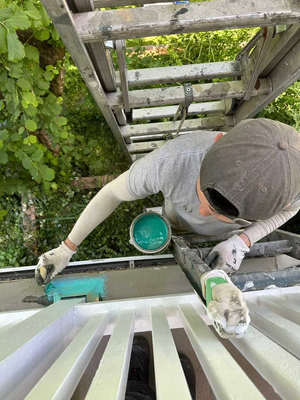 Renaissance Painting crew member applying teal primer to deck trim in Vancouver, BC