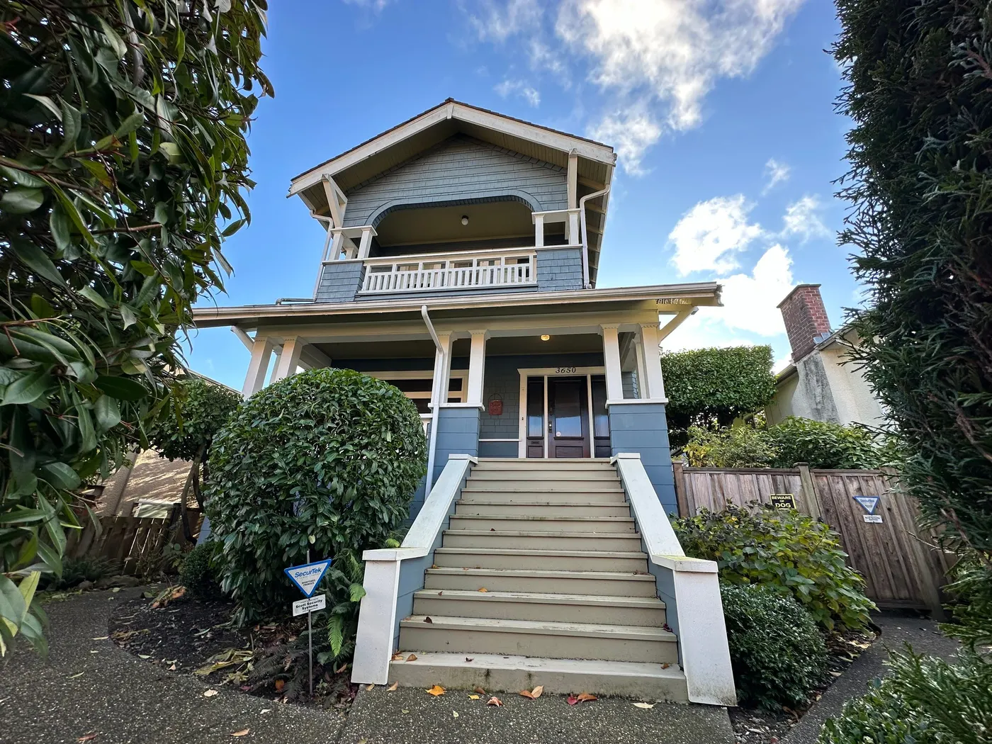 Blue-gray Craftsman house exterior with a grand painted staircase and covered balcony, painted by Renaissance Painting in Vancouver, BC.