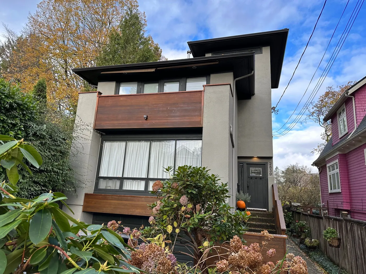 Modern gray stucco home exterior with dark trim and wood accents, painted by Renaissance Painting in Vancouver, BC.