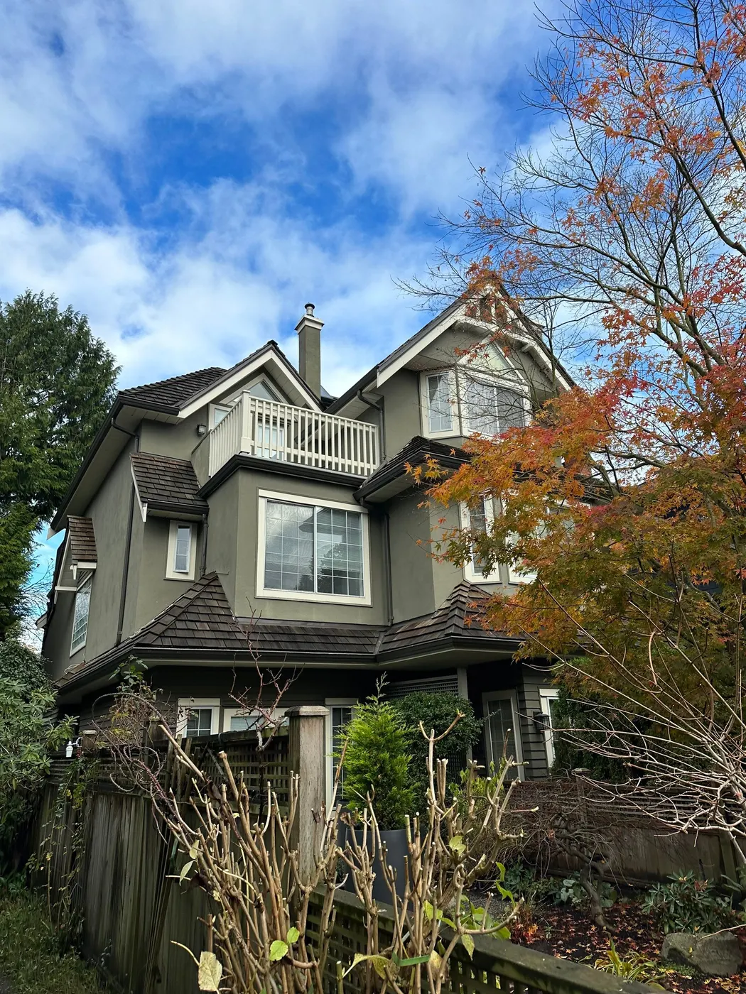 Olive gray stucco exterior on a multi-gable Tudor-style home, painted by Renaissance Painting in Vancouver, BC.
