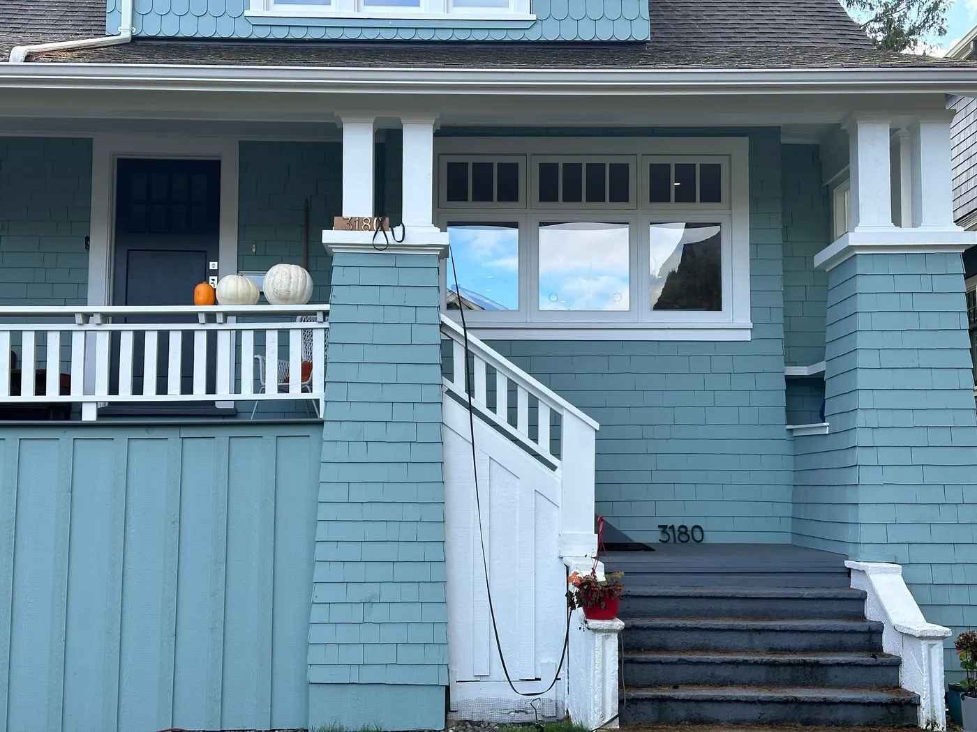 Teal blue Craftsman house exterior with white porch columns and shingle siding, painted by Renaissance Painting in Vancouver, BC.