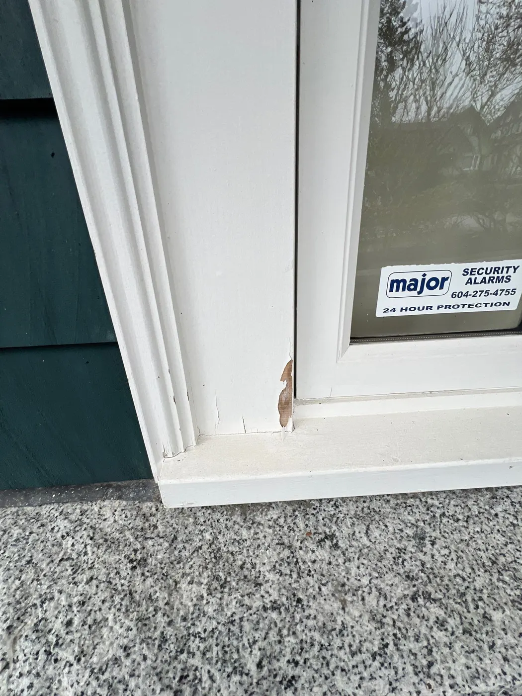 Chipped and rotting wood trim beside a window near the front entry of a Vancouver, BC home before painting and carpentry repair