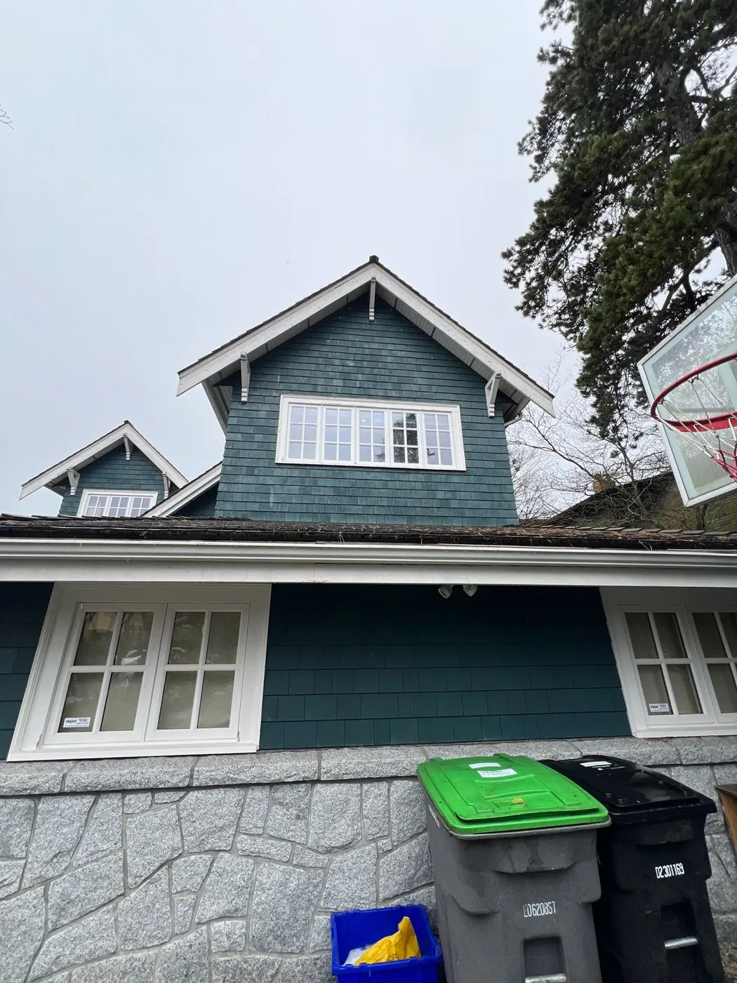 Front exterior of a dark teal cedar shingle character home in Vancouver, BC prior to a full repaint