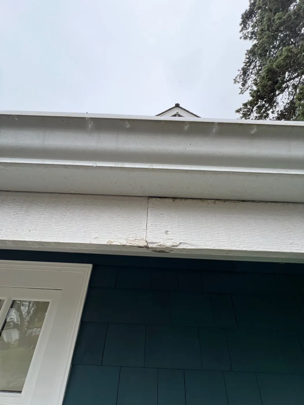 Peeling paint and a cracked joint on a roof eave fascia board at a Vancouver, BC residence