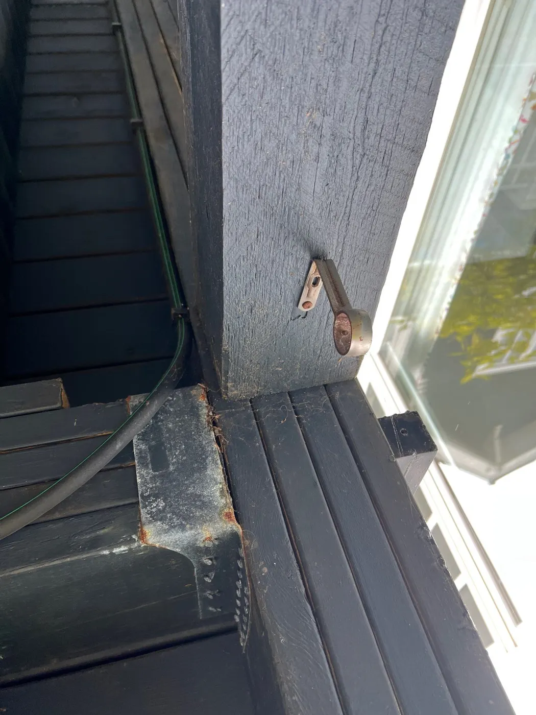 Narrow side yard path and stucco exterior wall of a Vancouver, BC home with hose bib and gate