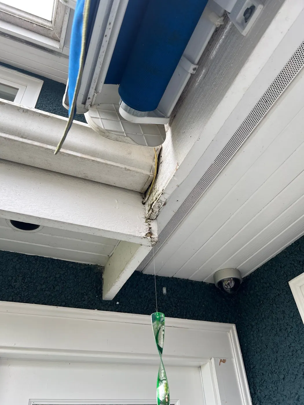 Rotted wood soffit corner and cracked trim under a covered porch roof at a Vancouver, BC home before carpentry repair