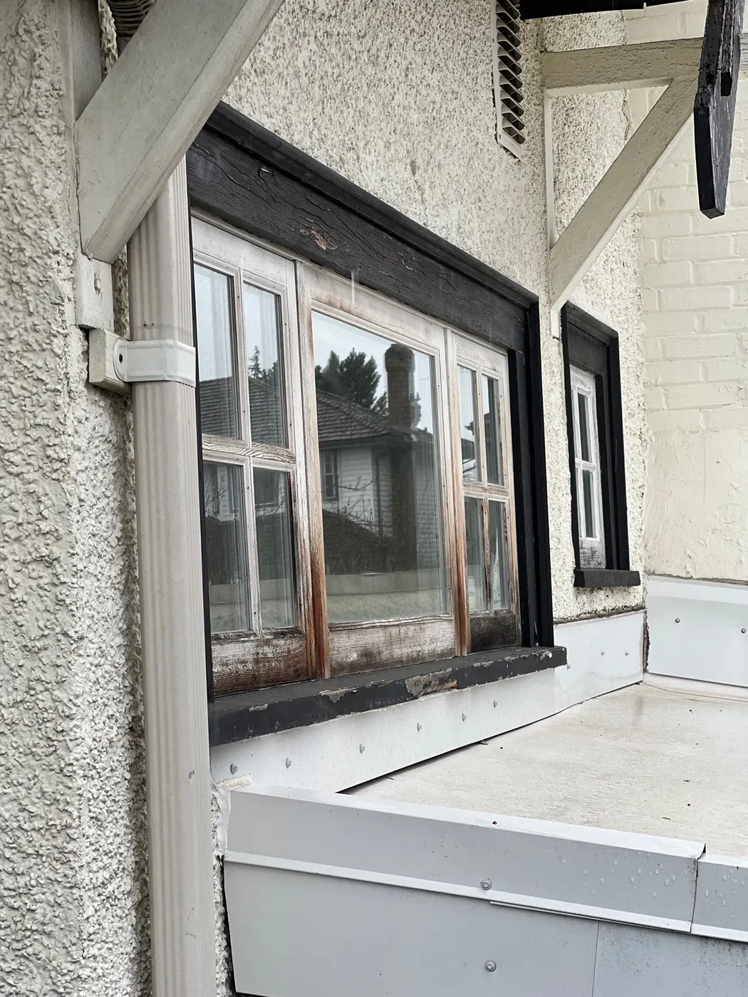 Weathered wood window frame with rotted trim needing carpentry repair before painting, Vancouver BC.