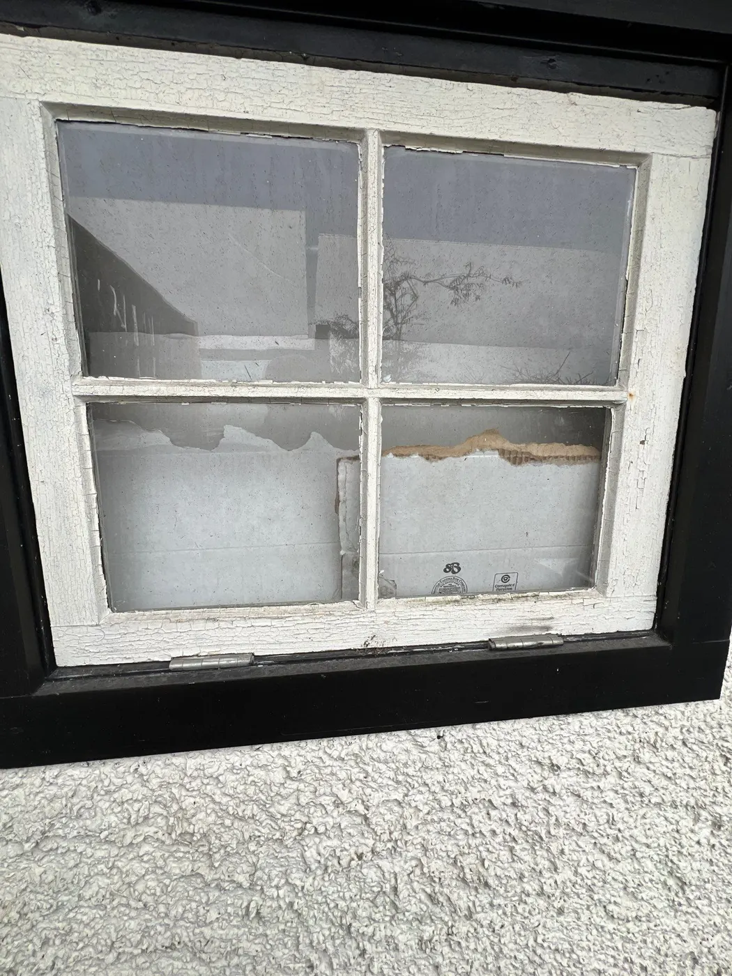 Peeling paint and cracked glazing on an original wood window, prepped for restoration in Vancouver, BC.