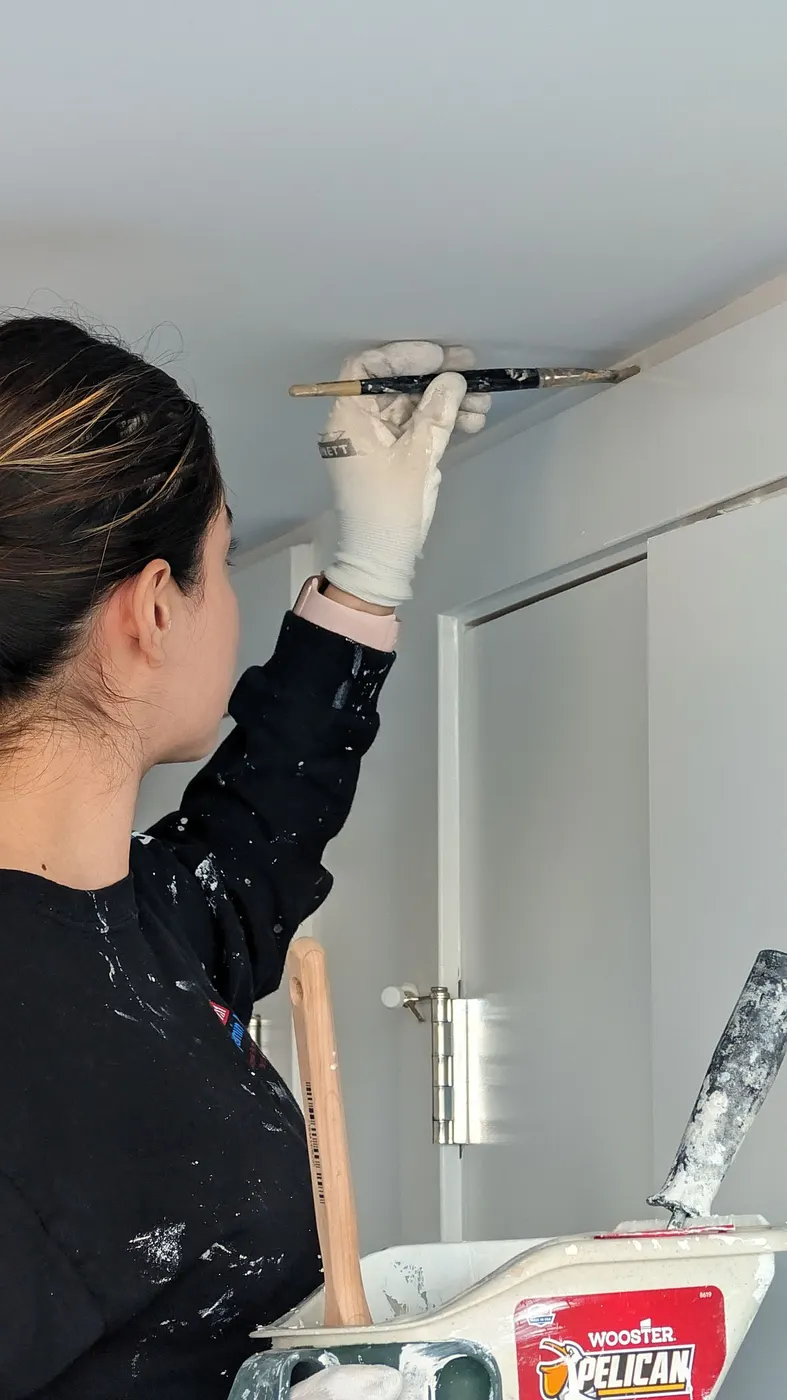 Painter cutting in a ceiling line with a brush in a Vancouver, BC condo