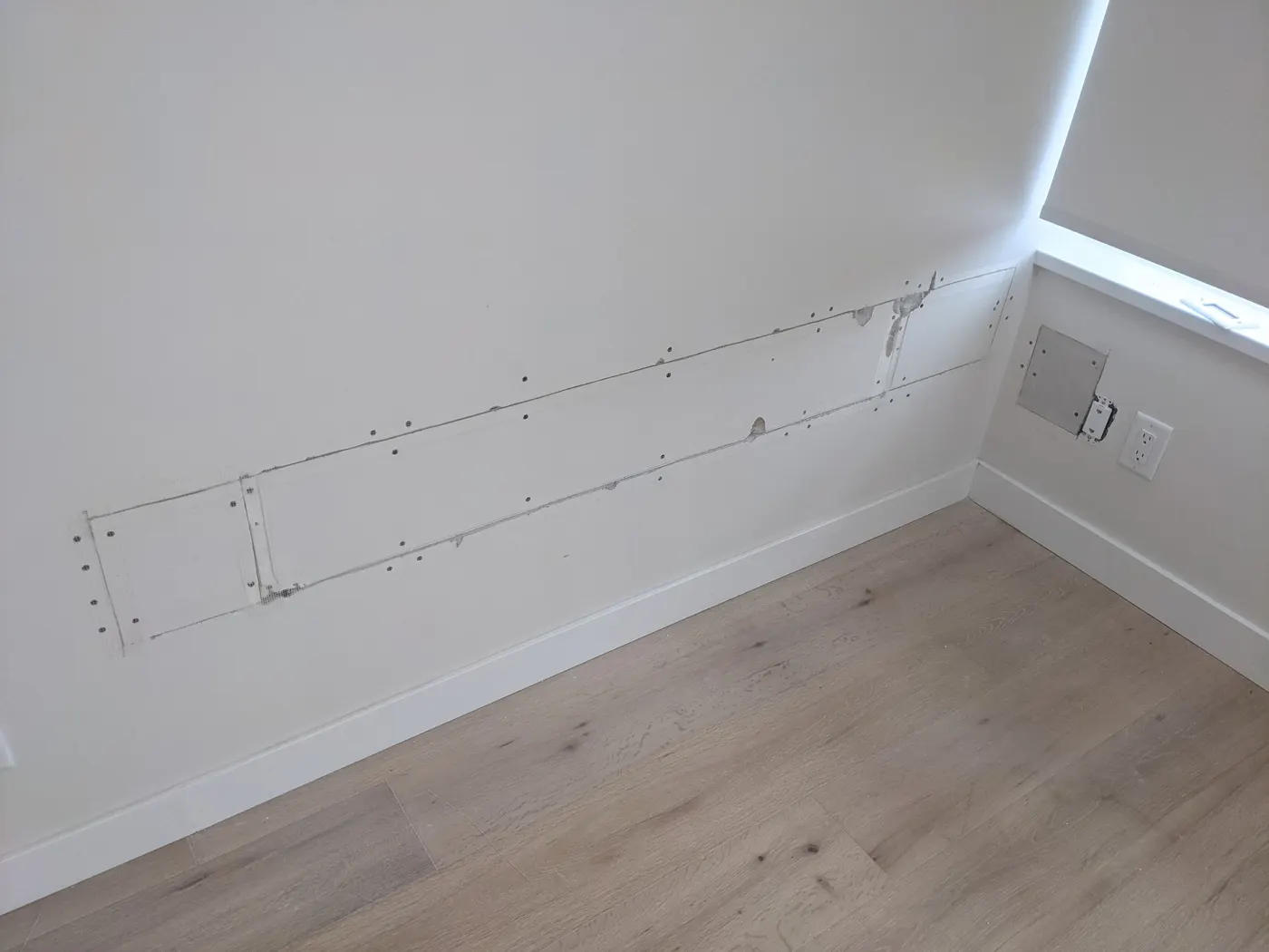 Drywall patch repair marks on a wall in a Vancouver, BC condo with a river view