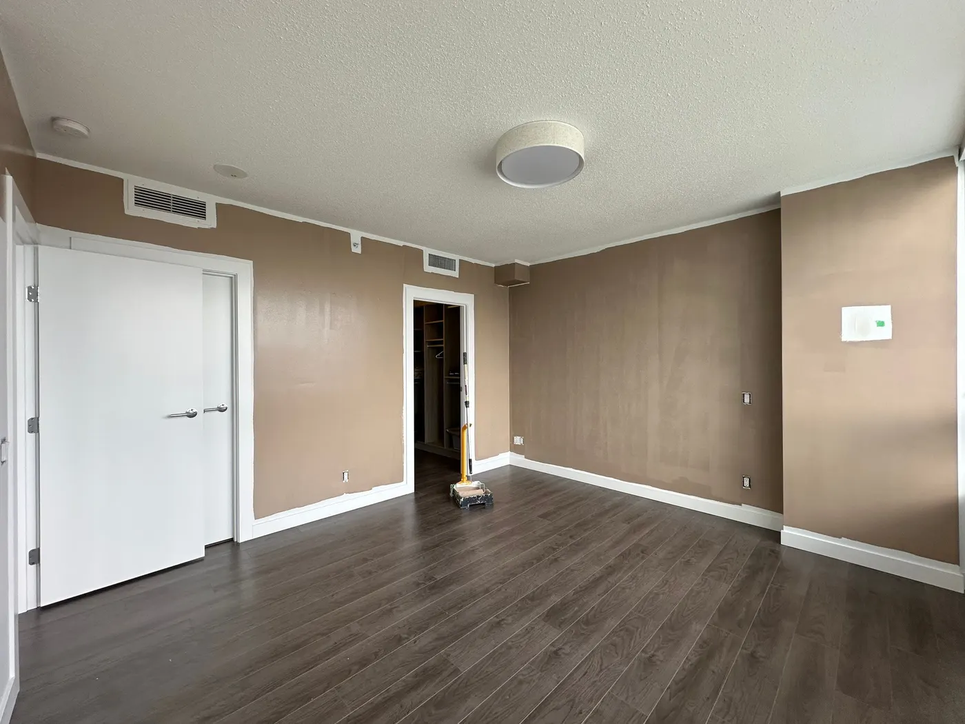 Freshly painted tan accent wall in a Vancouver, BC condo bedroom