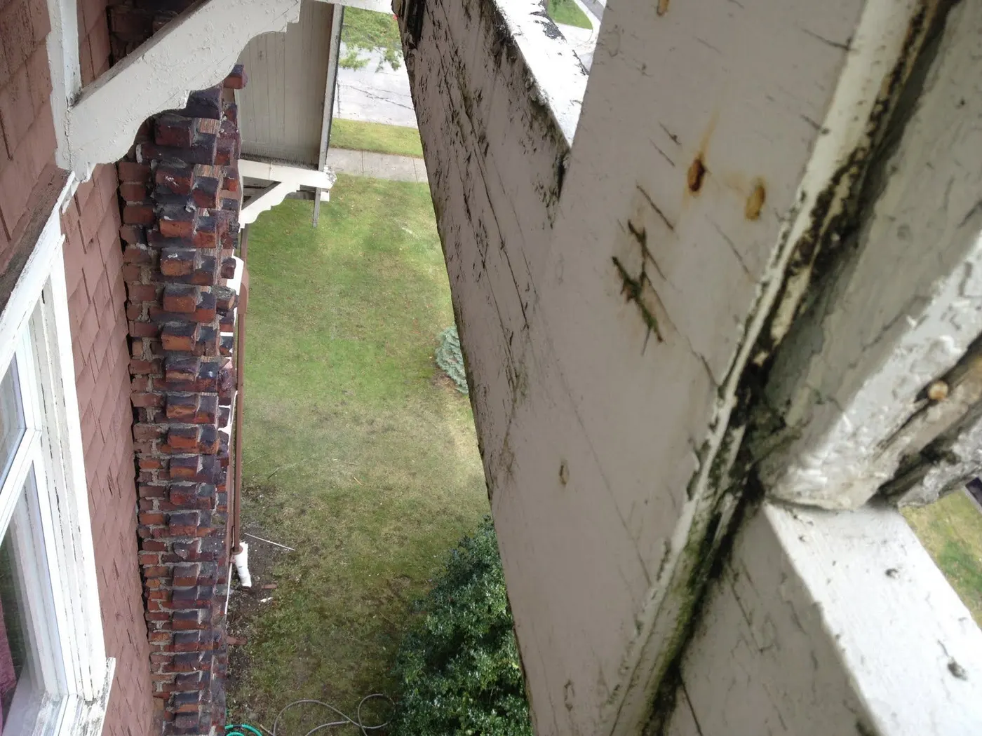 Weathered eave and brick chimney detail on a Vancouver, BC character home showing exterior wear