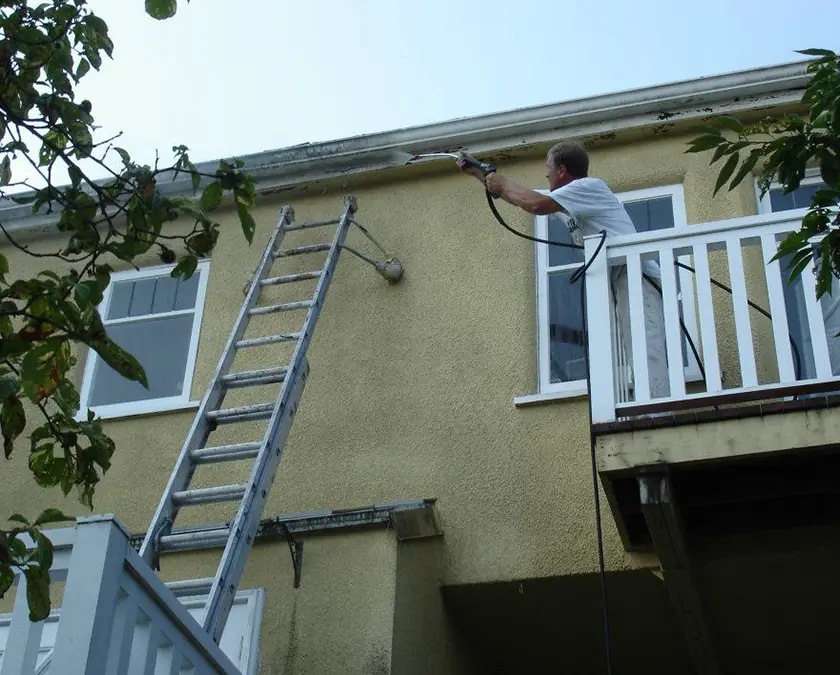 Renaissance Painting team member power washing exterior gutter.