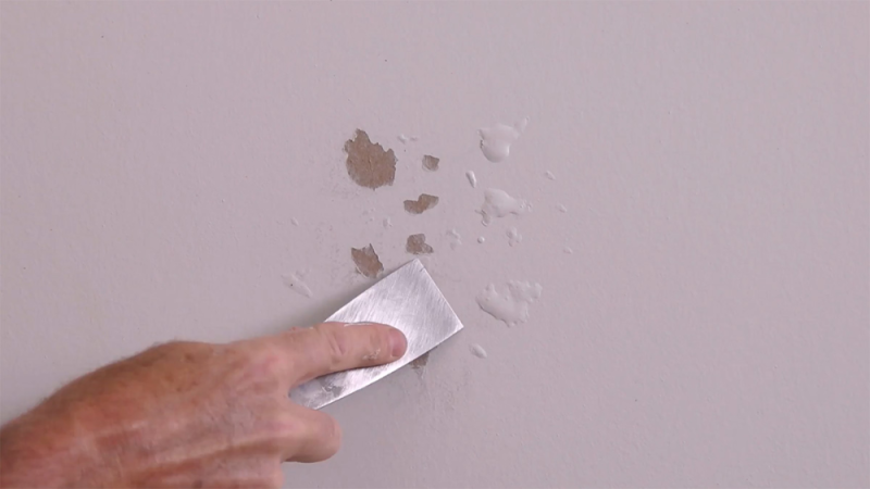 Before the next paint coat, scrape the bubbles with a putty knife and then sand with a fine grit sandpaper