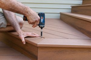 Worker installing composite wood decking.