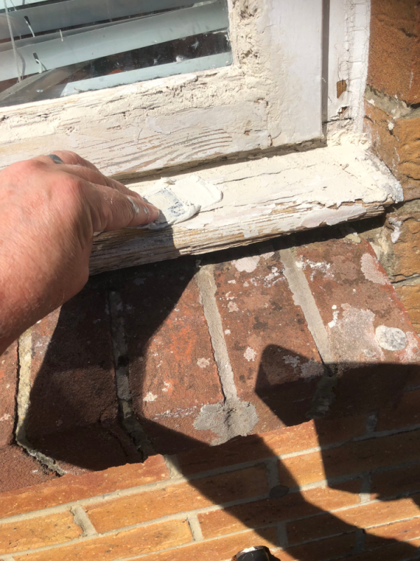 Spreading Wood filler on a Window Frame